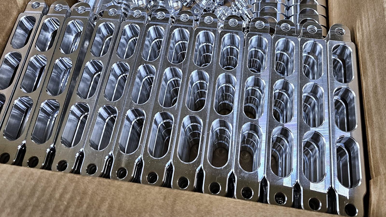Supports en aluminium usinés en série, rangés dans une boîte
